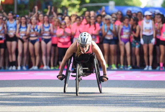 Archivo - Una mujer en silla de ruedas participa en una carrera por el Día de la Mujer.