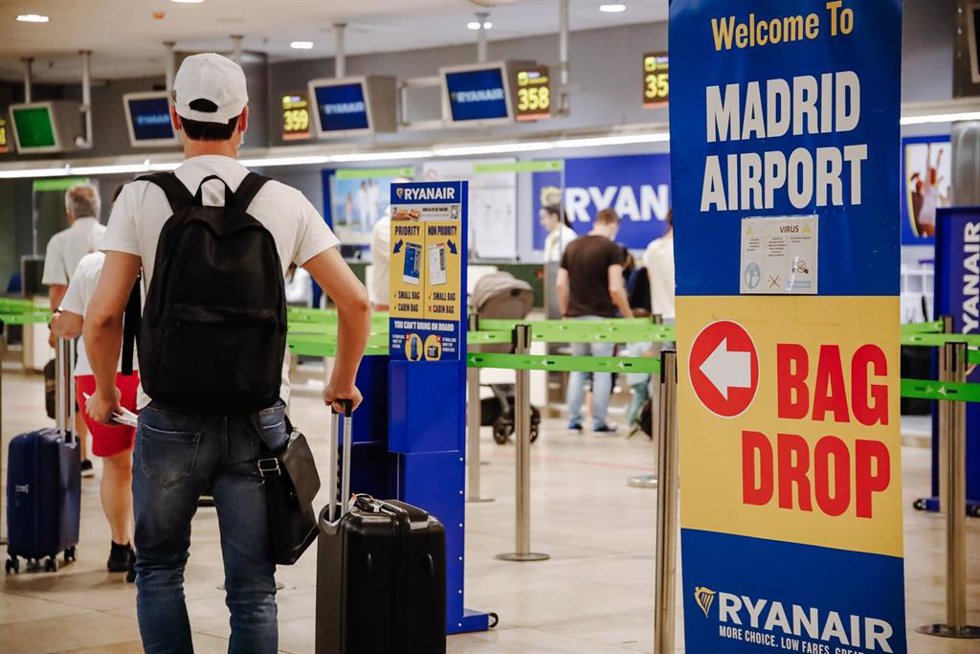 Varios pasajeros en el mostrador de Ryanair en un aeropuerto. 