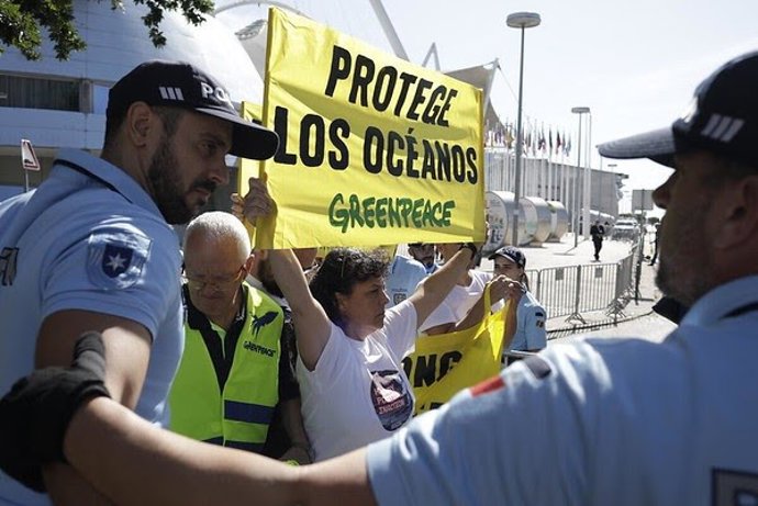 A Greenpeace International  activist holds a banner reading 'Protege Los Oceanos' (Protect the Oceans) at the UN Oceans conference in Lisbon (Portugal).