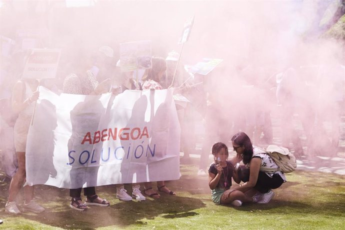 Una madre protege a su hija del humo provocado por unos botes durante la concentración de los trabajadores de Abengoa en la consejería de Economía, a 30 de junio de 2022 en Sevilla (Andalucía, España)