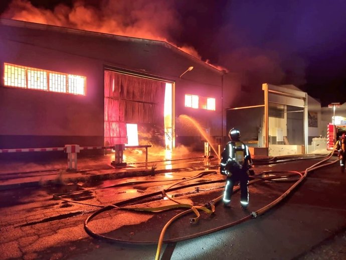 Un bombero en las labores de extinción de dos naves industriales en El Chorrillo