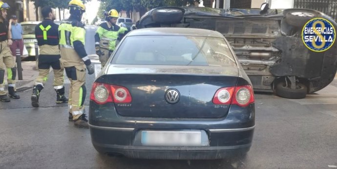 Vuelco de un vehículo como consecuencia de un accidente de tráfico en la barriada de El Cerro del Águila.