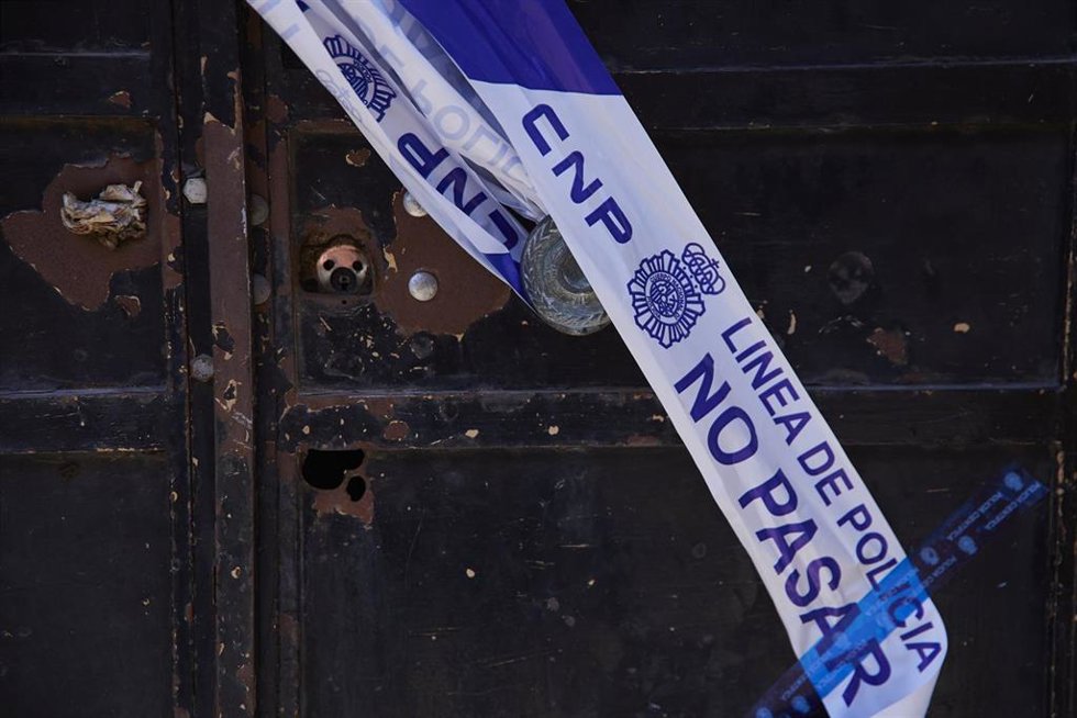 Detalle de la puerta precintada de la vivienda de la calle Fornet Domínguez, de la localidad sevillana de Dos Hermanas, donde fue asesinada una mujer de 53 años por su marido, que luego se suicidó.