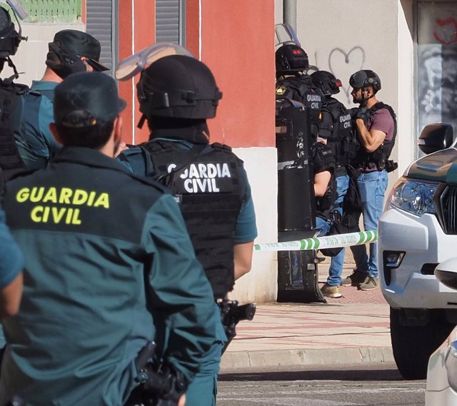 Agentes en las inmediaciones de la vivienda donde un hombre se ha atrincherado con un rehén tras matar a otro en Santovenia, Valladolid. 
