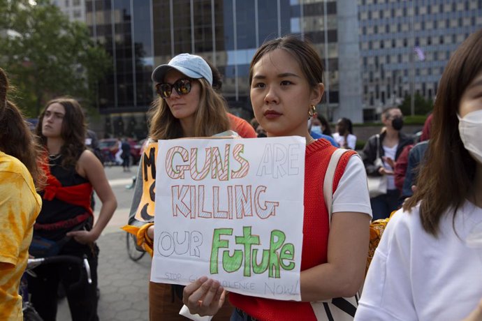 Archivo - 26 May 2022, US, New York: A member of the "Youth Over Guns" organization holds a placard a banner during a rally in solidarity with victims and survivors of the Buffalo and Uvalde massacres calling on legislators to provide a future free of g