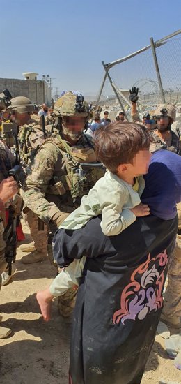 Archivo - Un militar del Mando de Operaciones Especiales del Ejército de Tierra español conversa con una mujer que lleva en brazo a un menor durante el trabajo de evacuación en el aeropuerto de Kabul, a 23 de agosto de 2021, en Kabul, (Afganistán)