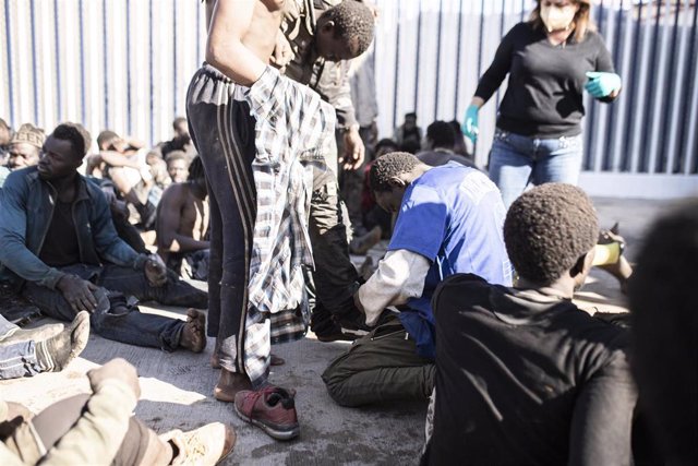 Archivo - Varios migrantes tras saltar la valla en Melilla 