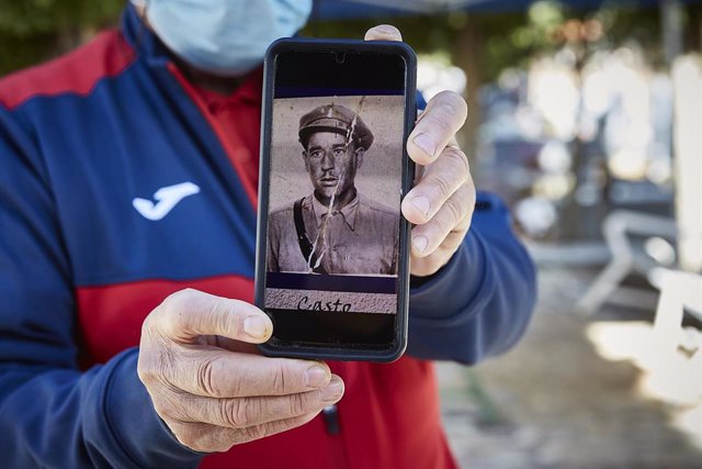 Archivo - Un hombre muestra una fotografía de un familiar durante la búsqueda y exhumación de 21 víctimas de la dictadura franquista de Guadalajara