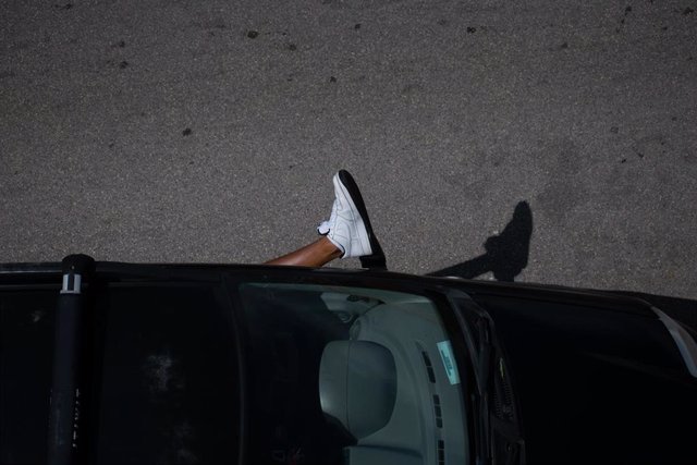 Un hombre saca el pie de su vehículo en medio de una ola de calor en Tarento, Italia