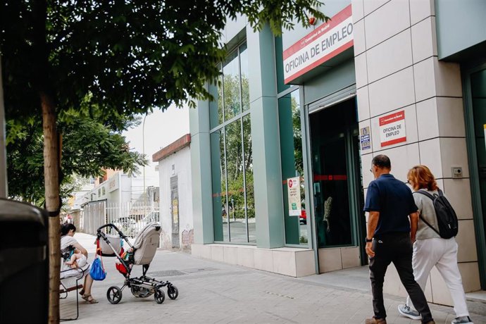 Archivo - Dos personas pasan por delante de una oficina del Servicio Público de Empleo Estatal.