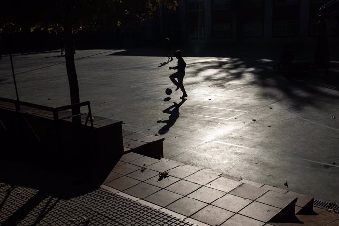 Archivo - Un niño juega a la pelota en el patio de un colegio.