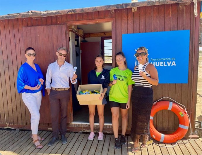 Aguas de Huelva y Ayuntamiento reparten unos ceniceros reutilizables en la playa de El Espigón.