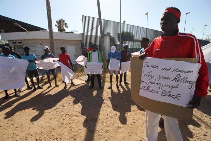 Un grupo de migrantes de origen subsahariano con carteles, durante una concentración en las inmediaciones del CETI para protestar por los hechos ocurridos el pasado 24 de junio en Melilla,