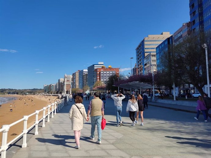 Archivo - Personas paseando por el muro de la playa de San Lorenzo, Gijón.