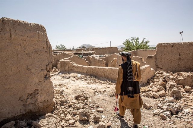 Desplazado afgano camina por una barriada destruida
