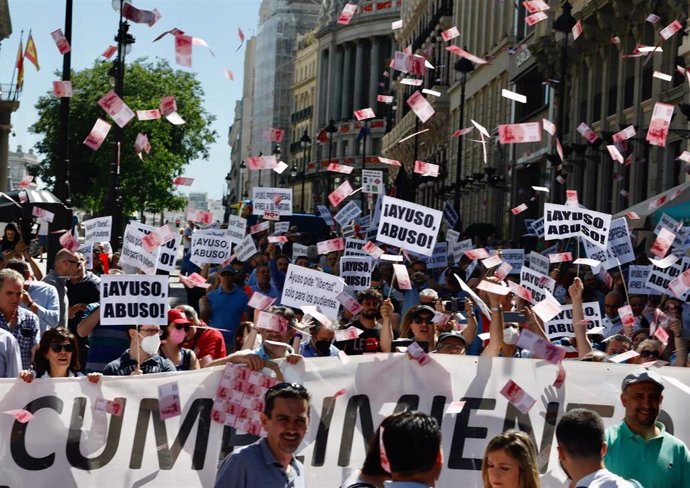Archivo - Manifestantes lanzan billetes al aire durante una marcha contra la reforma de la Ley de Transportes, a 1 de junio de 2022, en Madrid (España).