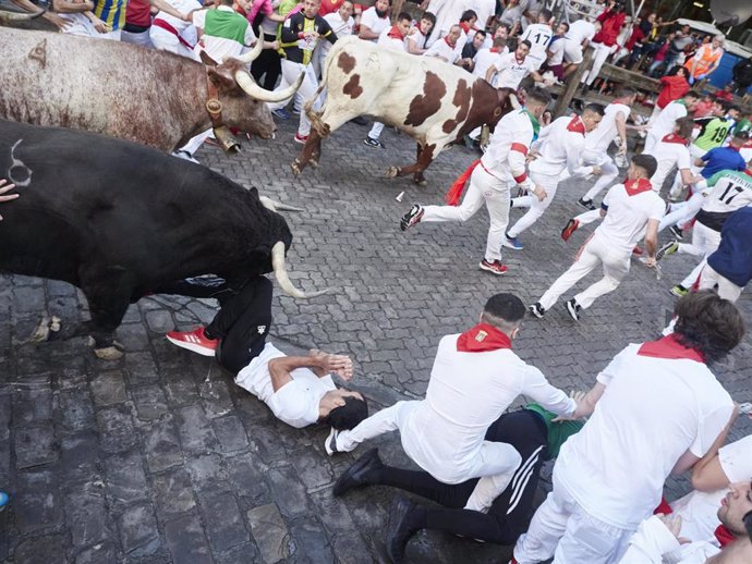 Un hombre tirado en el suelo durante el primer encierro de las Fiestas de San Fermín 2022 de la ganadería de Núñez de Cuvillo, a 7 de julio de 2022, en Pamplona, Navarra (España). 