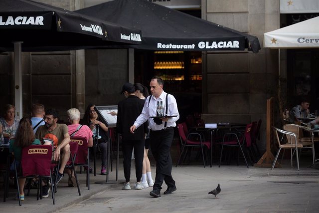 Un camarero sostiene una bandeja en la plaza Real de Barcelona, en una imagen de archivo.