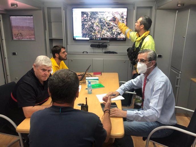 El secretario autonómico de Seguridad y Emergencias de la Generalitat valenciana, José María Ángel, junto a responsables de los medios de extinción en la reunión de coordinación de este jueves en el Puesto de Mando Avanzado del incendio de Venta del Mor