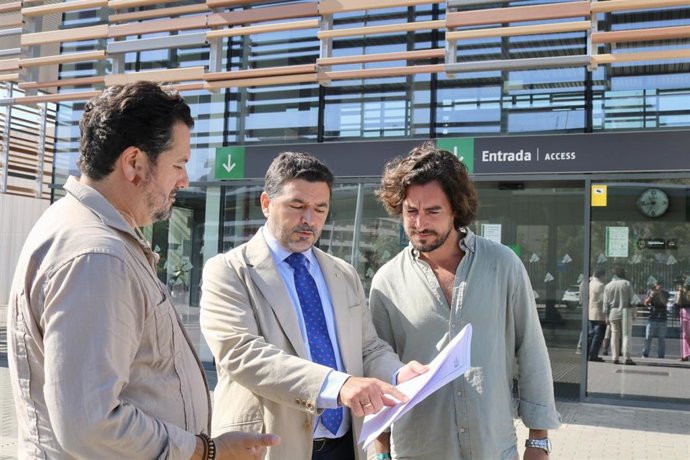 El secretario general del PP de Huelva y senador, José Enrique Sánchez (centro), en la estación de trenes.