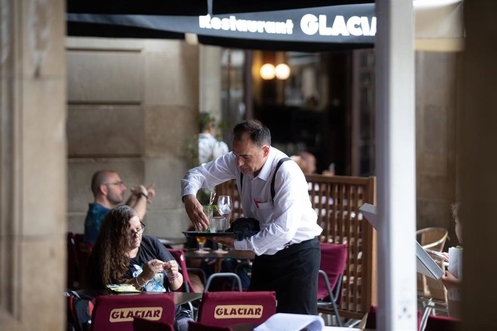 Un camarero limpia una mesa en la plaza Real de Barcelona, a 15 de junio de 2022, en Barcelona, Catalunya (España).