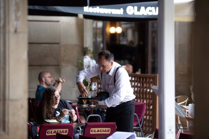 Un cambrer neteja una taula en la plaa Real de Barcelona, a 15 de juny de 2022, a Barcelona, Catalunya (Espanya). 
