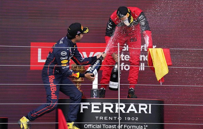 First-placed Spanish F1 driver Carlos Sainz Jr. of team Ferrari (L) celebrates with second-placed Mexican F1 driver Sergio Perez of Red Bull racing team on the podium after the British Grand Prix 2022 at Silverstone Circuit