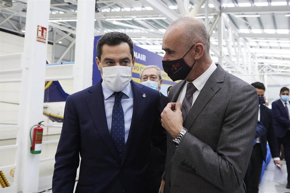 Archivo - El presidente de la Junta, Juanma Moreno, (i) dialoga con el Teniente de Alcalde del Sevilla, Antonio Muñoz, (d) durante la inauguración del nuevo Hangar de Ryanair en Sevilla, a 15 de diciembre de 2021 en Sevilla (Andalucía, España)