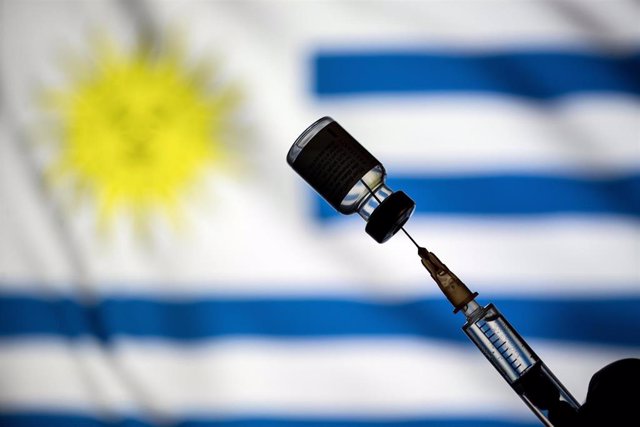 Archivo - Montaje de una vacuna con la bandera de Uruguay