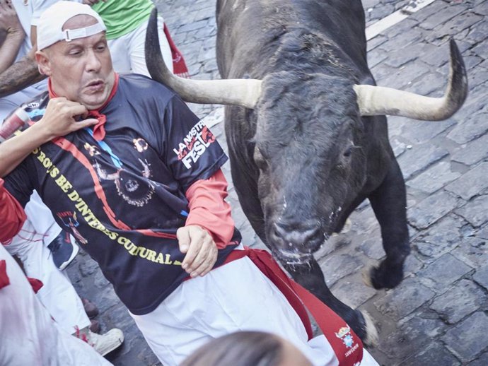 Un mozo corre delante de un toro en el segundo encierro de las fiestas de San Fermín de 2022.