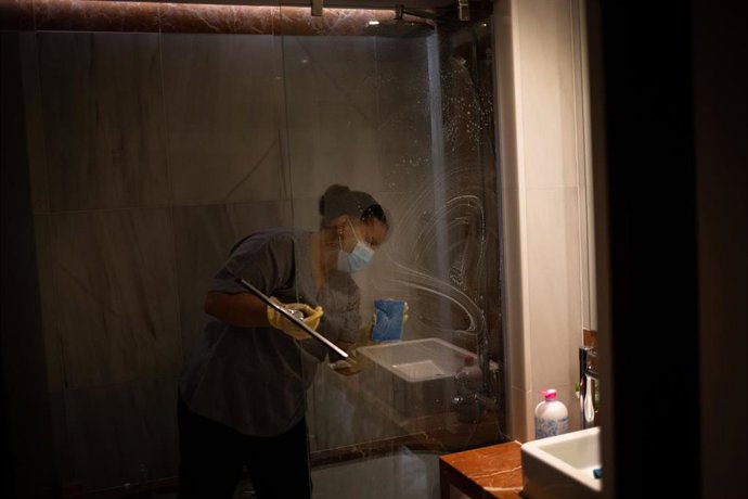 Archivo - Una camarera de piso limpia una habitación de un hotel en Barcelona.