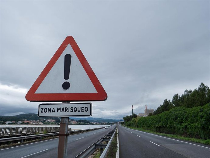 Vista de una señal de riesgo para el marisqueo, por la contaminación de la ría, cerca de una fábrica de celulosa