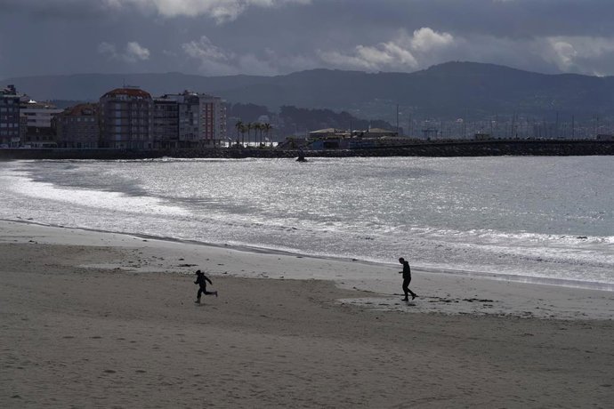 Archivo - Varias personas pasean por la playa de Silgar en Sanxenxo