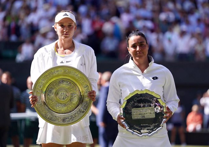 Kazakh winner Elena Rybakina (L)and Tunisia's Ons Jabeur pose with their trophies after their women's singles final match on day thirteen of the 2022 Wimbledon Grand Slam tournament at the All England Lawn Tennis and Croquet Club