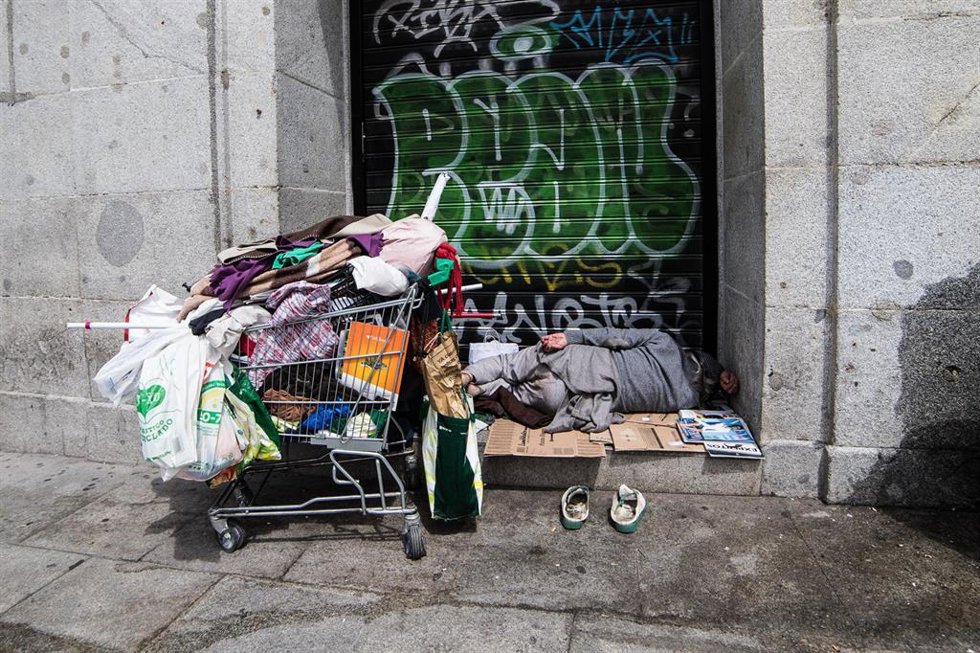 Archivo - Una persona sintecho duerme en la calle (archivo).