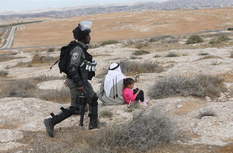 Archivo - Un soldado isarelí y civiles palestinos en Hebrón, Cisjordania