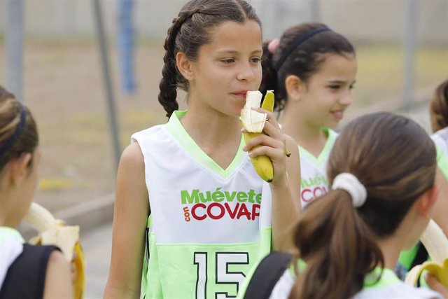 Una niña comiendo un plátano