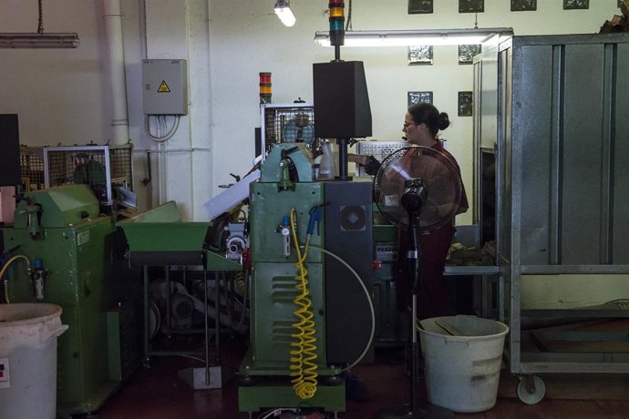 Una trabajadora maneja maquinaria en una fábrica.