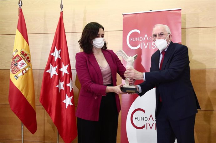 Archivo - La presidenta de la Comunidad de Madrid, Isabel Díaz Ayuso (i), recibe premio Sociedad Civil de la Fundación Civismo de parte del presidente de la fundación, Julio Pomes (d), en Madrid (España), en una imagen de archivo.