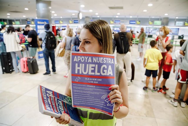 Una trabajadora de Ryanair con carteles durante una concentración en la Terminal 1 del Aeropuerto Adolfo Suárez Madrid Barajas, a 1 de julio de 2022.