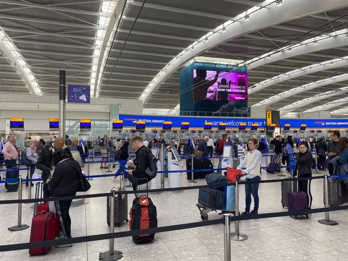 Archivo - FILED - 23 April 2022, United Kingdom, London: Passengers queue to check-in bags in departures at Terminal 5 at Heathrow Airport. Heathrow Airport has announced it will remain loss-making in 2022 as "demand remains very volatile".