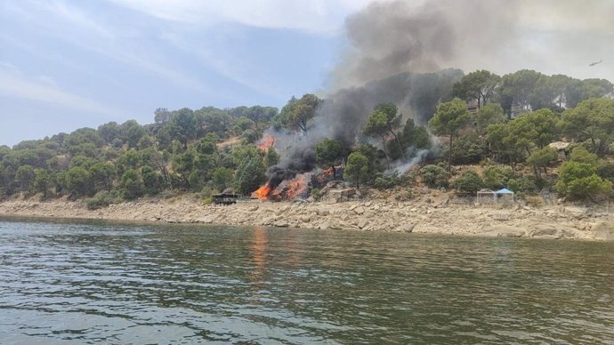 Bomberos luchan contra un pequeño incendio forestal que comenzó en una casa junto al pantano de San Juan