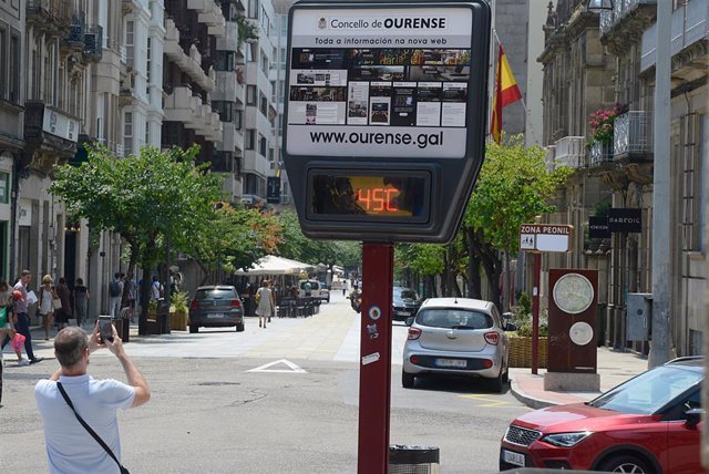 Un hombre hace una fotografía a un termómetro en la calle que marca 45 grados, a 12 de julio de 2022, en Orense, Galicia (España). 