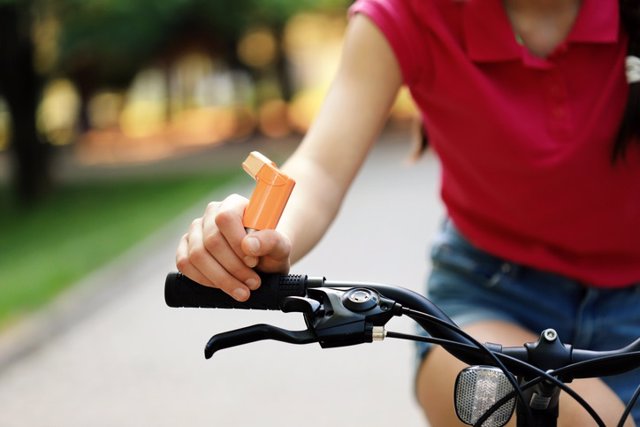 Archivo - Mujer montando en bici, inhalador, asma.