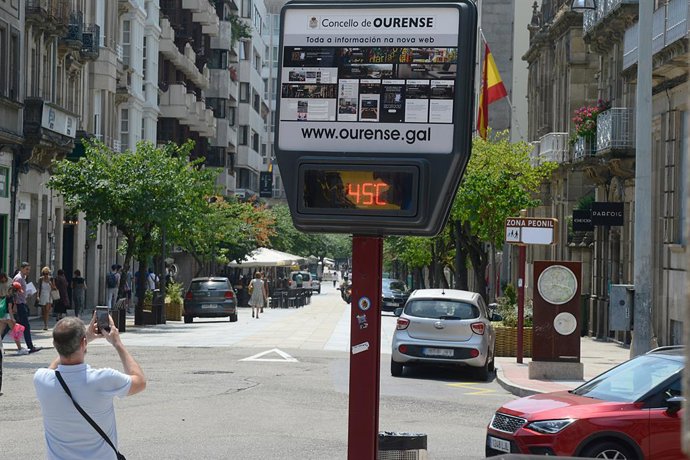 Un hombre hace una fotografía a un termómetro en la calle que marca 45 grados, a 12 de julio de 2022, en Orense, Galicia (España). 