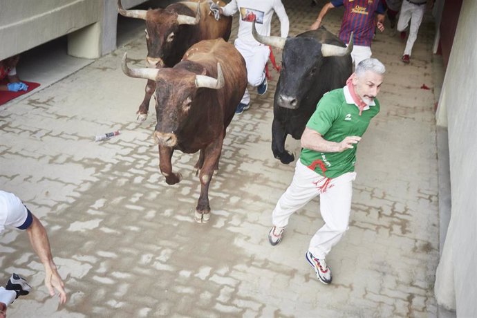 Un hombre corre durante el último encierro de las Fiestas de San Fermín 2022 con toros de Miura, a 14 de julio de 2022, en Pamplona, Navarra (España). Las fiestas en honor a San Fermín, patrón de Navarra, acaban hoy con el cántico del Pobre de mí. Dur