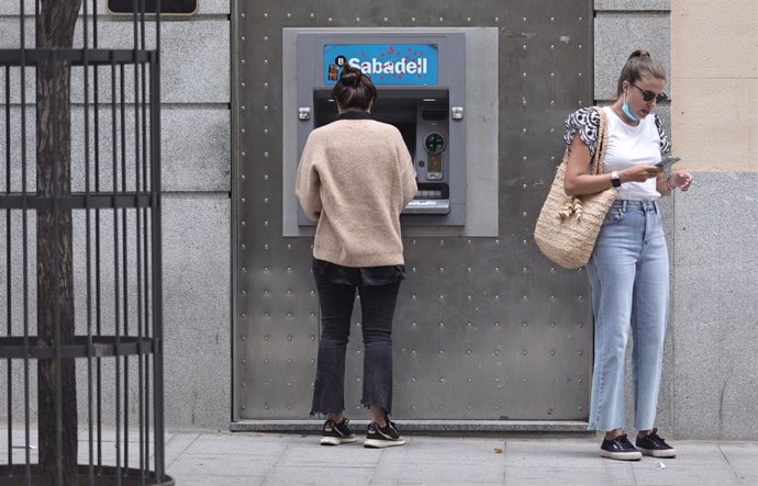 Archivo - Dos mujeres en un cajero de una entidad financiera