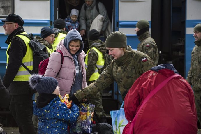 Archivo - febrero de 2022, Przemysl, Podkarpackie, Polonia: Se ve a un soldado dando comida a un niño ucraniano que llegó a la estación de tren de Przemysl..En el quinto día de la invasión rusa sobre Ucrania, miles de solicitantes de asilo llegan en tre