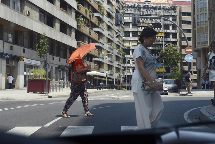 Dos personas caminan por una vía en plena ola de calor, a 12 de julio de 2022, en Orense, Galicia (España). Los termómetros de la práctica totalidad del territorio gallego alcanzarán valores extremos debido a la ola de calor que comenzó la semana pasa