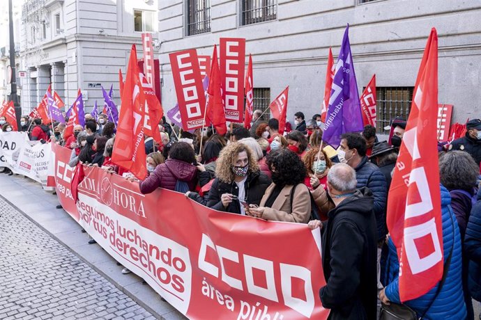 Archivo - Varias personas sostienen una pancarta y banderas de CCOO en una protesta en favor de los empleados públicos